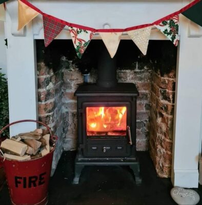 Firefox stove fitted in a fireplace with bunting hanging from the mantlepiece