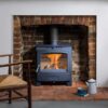 The Arada Hamlet Solution 5 widescreen multi-fuel stove shown in a brick fireplace with brick grate.
