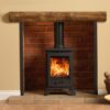 Capital Bassington compact multi-fuel stove set into a fireplace with cream painted wall and wooden mantlepiece.