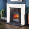 Capital Bassington multi-fuel stove set into a fireplace with traditional white surround and dark blue painted walls.