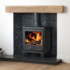 Capital Vega multi-fuel stove in a fireplace with white painted walls, grey interior and wooden mantlepiece.