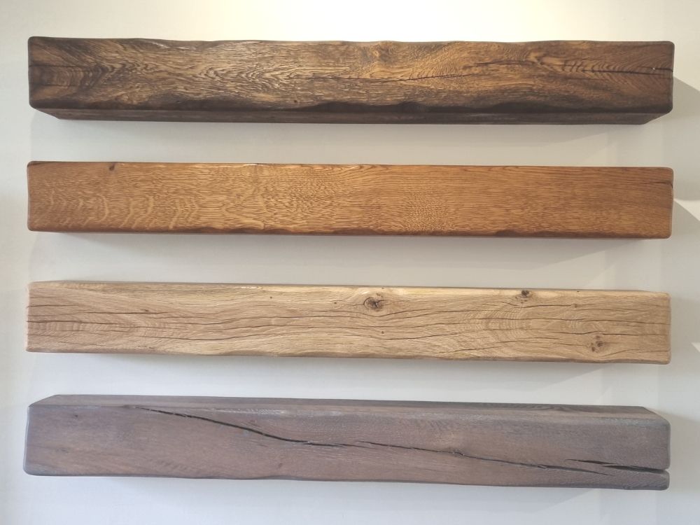 Four oak mantles fitted on the wall in a range of coloured wood stains.