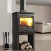A Portway P2 Contemporary multi-fuel stove shown in the middle of a room with white painted walls and logs stored underneath.
