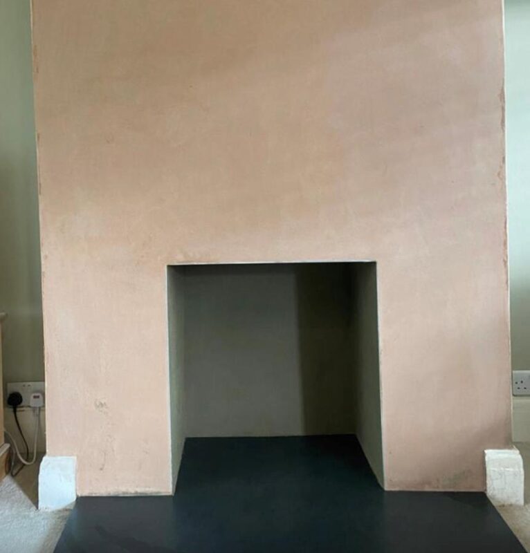 A chimney breast which has been plastered and is ready to paint.