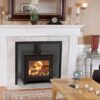 A Saltfire ST3 stove in a traditional fireplace with white surround and mirror over the mantlepiece.