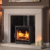 A Woodtec 5W wood-burning stove fitted in a traditional stone fireplace.