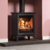 Charlton & Jenrick's Woodtec 5W Style wood-burning stove shown in a contemporary fireplace with pale pink painted walls.