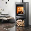 A freestanding woodburning stove shown with log store incorporated into the design, in a contemporary living space.