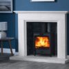 A cosy living room with deep blue painted walls and a Charlton & Jenrick Fireline FQ5W multi fuel stove burning brightly in the stone fireplace.