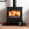 An Esse 105 wood burning stove shown in a living room with wooden floor and a slate hearth