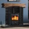 A Fireline FT8 woodburning stove in a cosy living room with dark painted walls and a wooden mantlepiece.