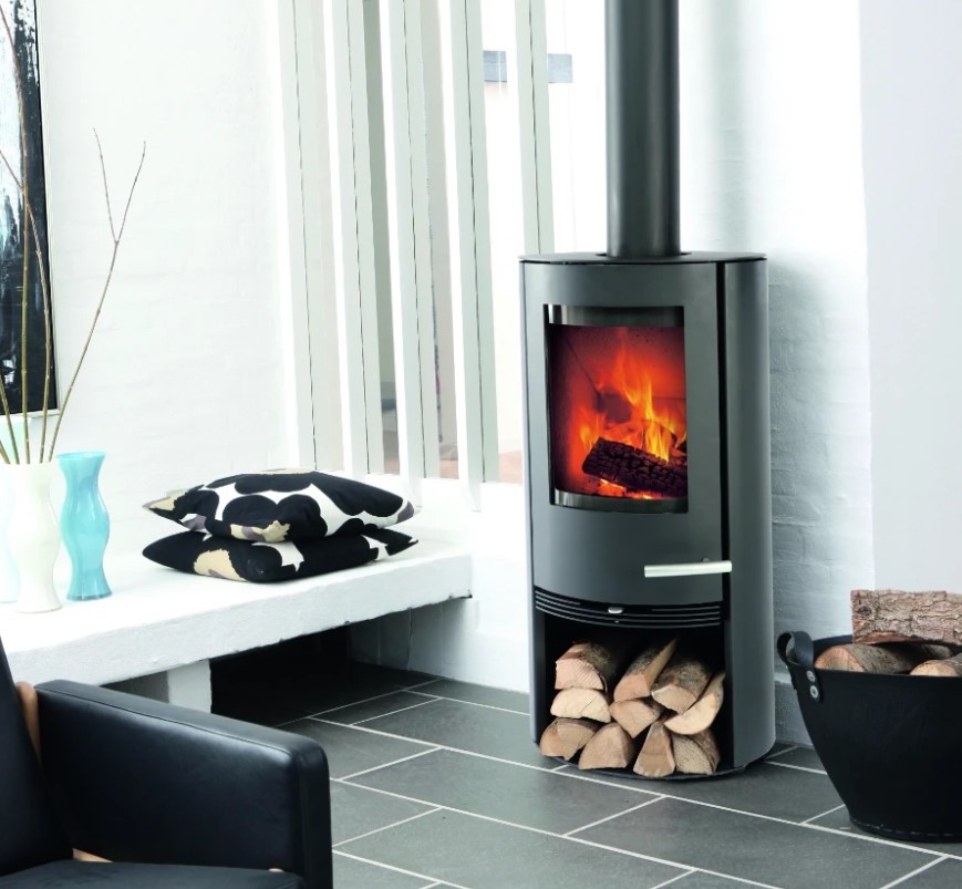 A cylindrical freestanding black Termatech wood-burning stove shown in a contemporary living room.