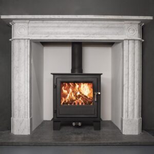 A multifuel stove shown in a chimney recess with white mantlepiece surround.
