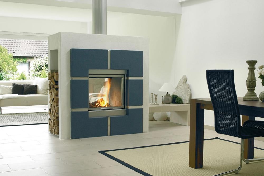 A woodburning stove which is set into a freestanding wall between two rooms so that the flames can be seen from both sides.
